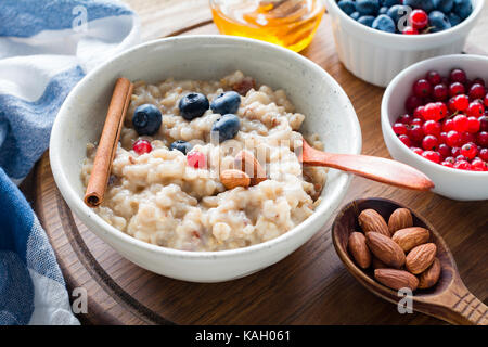 Gruau d'avoine avec des bleuets, les amandes et les raisins dans un bol. petit-déjeuner sain, suivre un régime, repas équilibré concept Banque D'Images