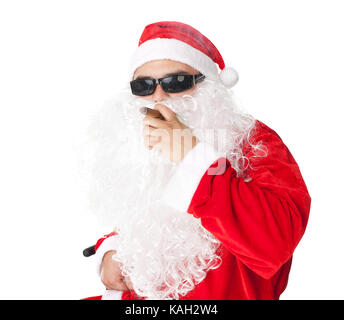 Santa Claus wearing sunglasses et fumer un cigare isolé sur fond blanc Banque D'Images