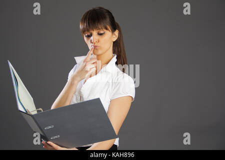 Jeune femme conçu avec des livres pour un travail sur un fond gris Banque D'Images