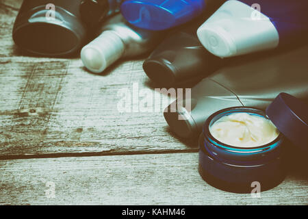 Les cosmétiques pour hommes. fond divers soins visage et corps produits cosmétiques pour hommes aménagé en demi-cercle sur châssis old wooden planks. copy space Banque D'Images