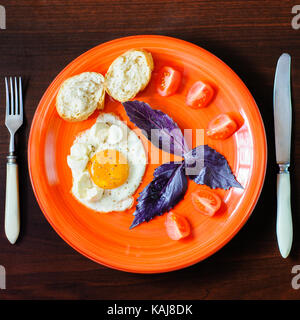 Les œufs et les tomates mozzarella au basilic sur plaque orange Banque D'Images