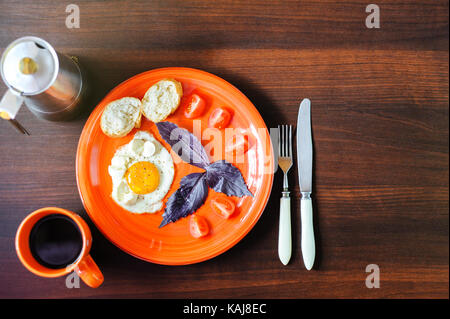 Les œufs et les tomates mozzarella au basilic sur plaque orange Banque D'Images