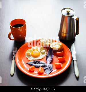 Les œufs et les tomates mozzarella au basilic sur plaque orange Banque D'Images