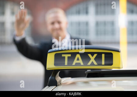 Close-up d'un taxi en face de Young Businessman Banque D'Images