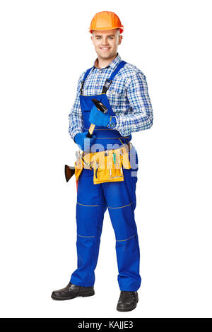 Full Length portrait of smiling young male construction worker with hammer,portant des vêtements, des gants et un casque isolé sur fond blanc Banque D'Images