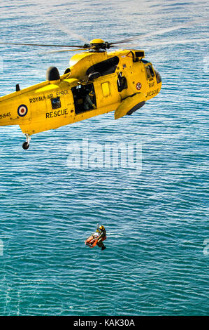 Sauvetage en falaise réelles par recherche et sauvetage de la raf helicoter Sea King à la plage de Meadfoot, Torquay, Devon, UK Banque D'Images