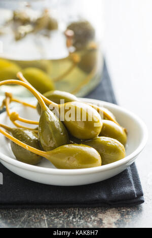 Caper marinés dans un bol de fruits sur la table de cuisine. Banque D'Images