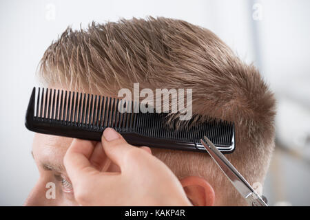 Jeune homme se coupe au salon de coiffure Femme Banque D'Images