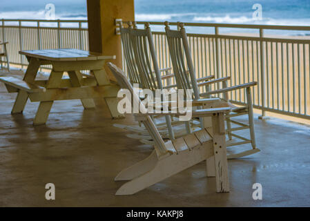 Des tables et des chaises sur une terrasse donnant sur la plage Banque D'Images