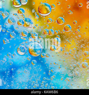 Gouttes d'huile sur une surface de l'eau avec un fond de couleur Banque D'Images