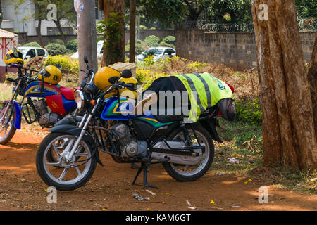 Chauffeur de taxi moto boda boda coin couchage sur moto par le bas-côté de la route, Nairobi, Kenya Banque D'Images