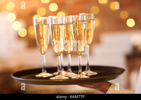 Verres de champagne sur le plateau à la lumière vive ou célébration du parti. Banque D'Images