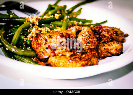 Pavé de boeuf au poivre noir, haricots verts au sésame on white plate Banque D'Images