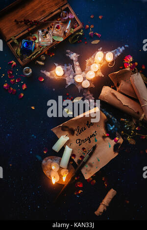 Place de la fantasy dragon faite de flamme de bougie, sort des parchemins, les herbes, les bouteilles de potion et pétales de rose. sorcière ou lieu de travail de l'assistant, et de l'halloween Banque D'Images