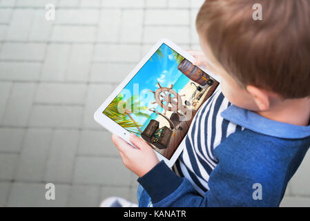 Garçon regardant la vidéo sur la tablette, et représente la scène de toxicomanie chez les enfants jouer à des jeux et des dessins animés sur la tablette et les téléphones mobiles. Banque D'Images