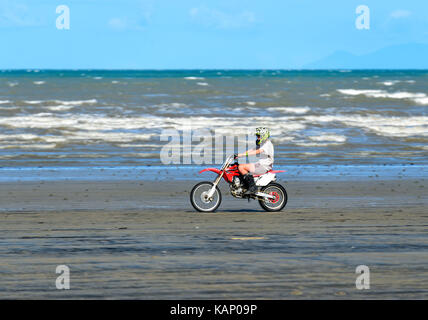 Jeune homme monté sur un vélo de saleté sur la plage à Mossman, Vitesse Extrême Nord du Queensland, Australie, Queensland, FNQ Banque D'Images