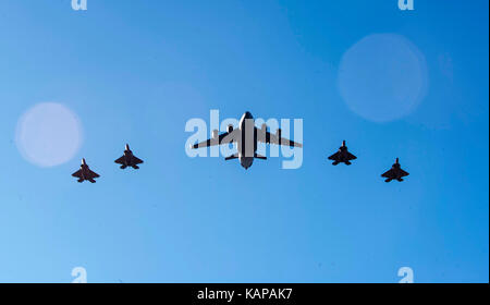 Un C-17 Globemaster III et quatre F-22 Raptors volent en formation de base commune sur Harbor-Hickam Pearl, HI, le 26 septembre 2017. Banque D'Images