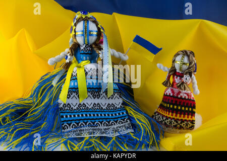 Handmade textill doll, poupées de chiffon à la main motanka sur le fond du drapeau de l'Ukraine. motanka - poupée folklorique ukrainienne la protection de la maison familiale Banque D'Images