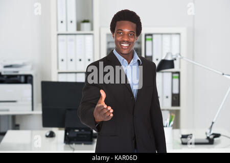 Portrait of young businessman offrant handshake in office Banque D'Images