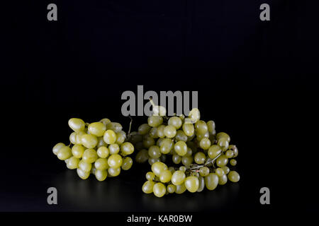 Raisin jaune dans un panier en osier sur un fond noir Banque D'Images