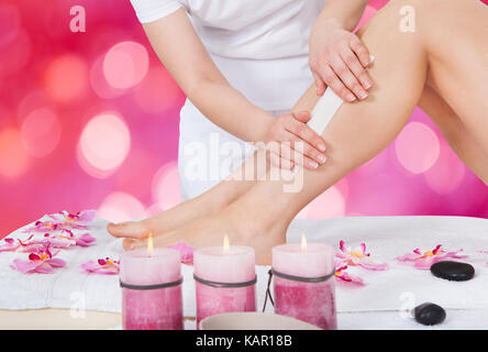 Portrait de femme beauté épilation jambe avec bande de cire au salon de Banque D'Images