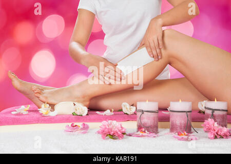 Portrait de femme beauté épilation jambe avec bande de cire au salon Banque D'Images