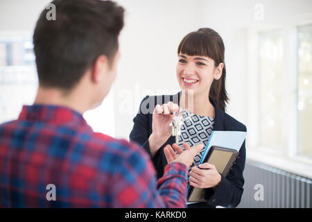 Récupérez les clés à l'homme nouvelle maison de female realtor Banque D'Images