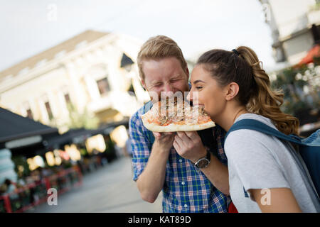 Couple heureux partager sur pizza street Banque D'Images