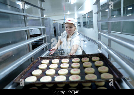 (170927) -- Beijing, sept. 27, 2017 (Xinhua) -- Les ouvriers effectuent une pâtisserie à gâteaux en compagnie de Tongzhou district Pékin capitale de la Chine, sept. 27, 2017. pour répondre aux besoins du marché pour le prochain festival de mi-automne, qui tombe le oct. 4 cette année, beaucoup d'entreprises de pâtisserie se précipitent leur production de gâteaux, un gâteau spécial pour ce festival. (Xinhua)(wjq) Banque D'Images