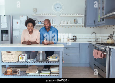 Smiling african couple leaning on leur à la maison de l'île de cuisine Banque D'Images