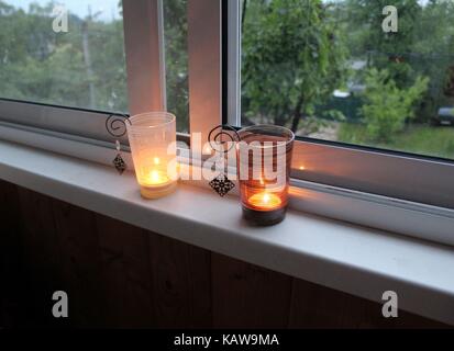 Deux bougies sur le rebord dans des supports de bougie. Banque D'Images
