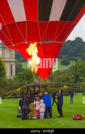 Personnes dans panier de ballon à air chaud sur le sol avec des flammes et des brûleurs à Sky Safari montgolfières à Longleat Wiltshire, Royaume-Uni en septembre Banque D'Images