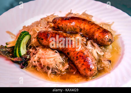 Saucisses bratwurst traditionnel servi avec la choucroute dans un restaurant, Augsbourg, Bavière, Allemagne Banque D'Images