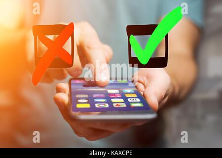 Voir de vert et rouge à la main l'icône tick sortir un smartphone interface d'un homme au bureau - concept d'idées Banque D'Images