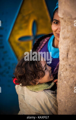 Portrait, souriant fille avec sa mère devant elle wouse à Merzouga, Maroc Banque D'Images