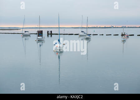 Bateaux dans le port de Langstone dans le Hampshire au coucher du soleil. Banque D'Images