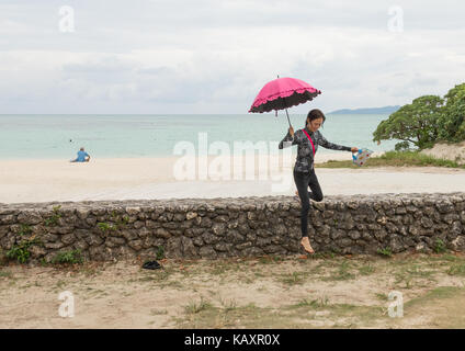 Femme japonaise avec un parapluie dans kondoi, plage de l'île de taketomi, îles yaeyama, Japon Banque D'Images