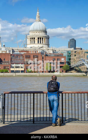 Londres, Angleterre, Royaume-Uni. L'homme sur la rive sud à la recherche sur la Tamise en direction de la Cathédrale St Paul Banque D'Images