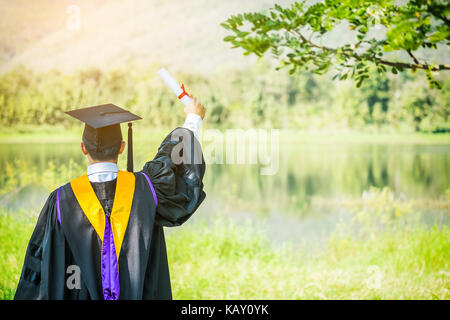 Il a diplômé hands up et célébrer avec certificat en main et il se sentir si le bonheur dans l'ouverture. Banque D'Images