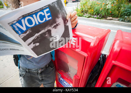 Un Reader views la dernière question d'impression du village voice newspaper, doté d''un fred mcdarrah photo de Bob Dylan,à New York le jeudi 21 septembre, 2017. l'emblématique de la voix, une fois que la voix de la contre-culture ne sera disponible sous forme numérique désormais. (© richard b. levine) Banque D'Images