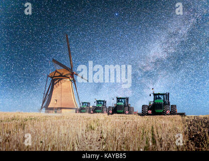 Nuit de printemps colorés avec des moulins à vent traditionnel néerlandais à rotterdam. canal jetée en bois près de la rive du lac. holland. aux Pays-Bas. superbe ciel étoilé et la voie lactée. Banque D'Images