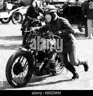 Femme poussant une moto classique à l'ascension de Kop Hill Banque D'Images