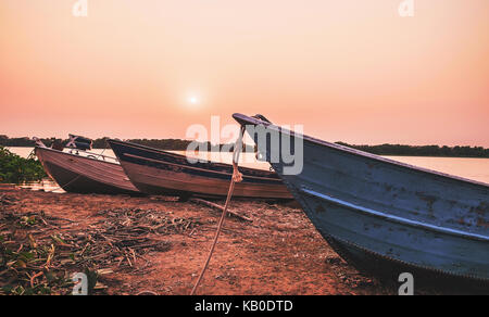 Paysage magnifique de vieux bateaux ancrés sur les marges de la rivière Paraguai Corumba, région du Pantanal au Brésil. Heure d'or au coucher du soleil. Banque D'Images