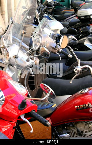 Les rangées de scooters et motos garés sur une rue de la ville Banque D'Images