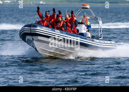 Les baleines et les bateaux d'excursion de macareux en approchant la pleine vitesse dans l'océan atlantique avec un groupe de touristes masculins et guide habillé en salopette chaude et la vie Banque D'Images