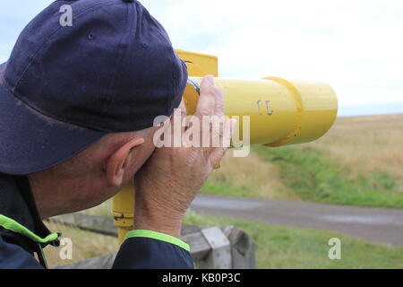 Man looking through telescope Banque D'Images