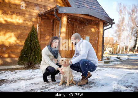 Young smiling girl with dog et petit ami sur les vacances d'hiver, Banque D'Images