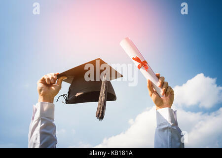 Le jour de la remise des diplômes, des images de diplômés célèbrent leur diplôme mis de main, un certificat et un chapeau à la main, sentiment de bonheur, date, cong Banque D'Images