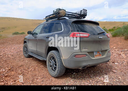 Un gris Jeep Cherokee avec une pelle et de gaz mis en garde sur les boîtes de red rock. Banque D'Images