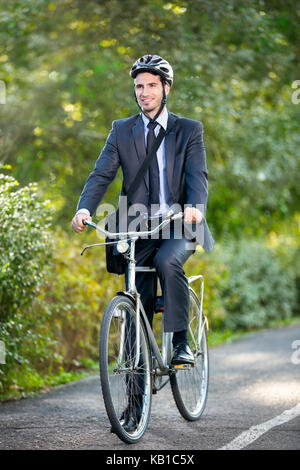 Toute la longueur du jeune homme d'une bicyclette au travail Banque D'Images